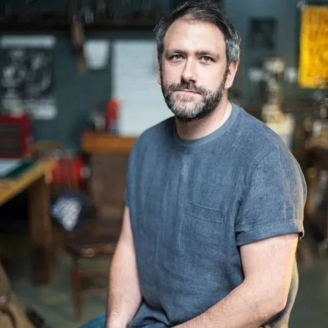 White middle aged man wearing woven blue slate tee shirt