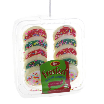 Glass ornament of packaged frosted cookies with colorful sprinkles on a white background