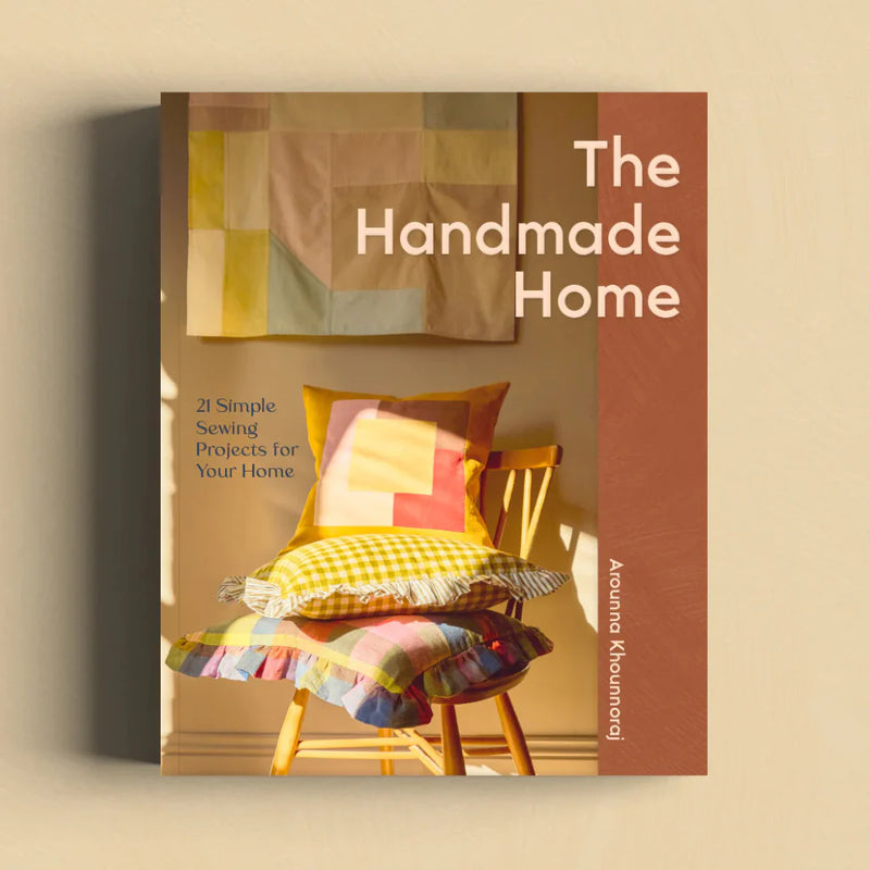 Book cover of 'The Handmade Home' with a chair and colorful cushions on a beige background