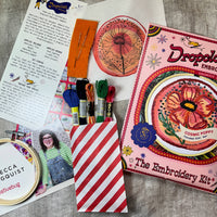 Embroidery kit with materials and instructions on a textured surface