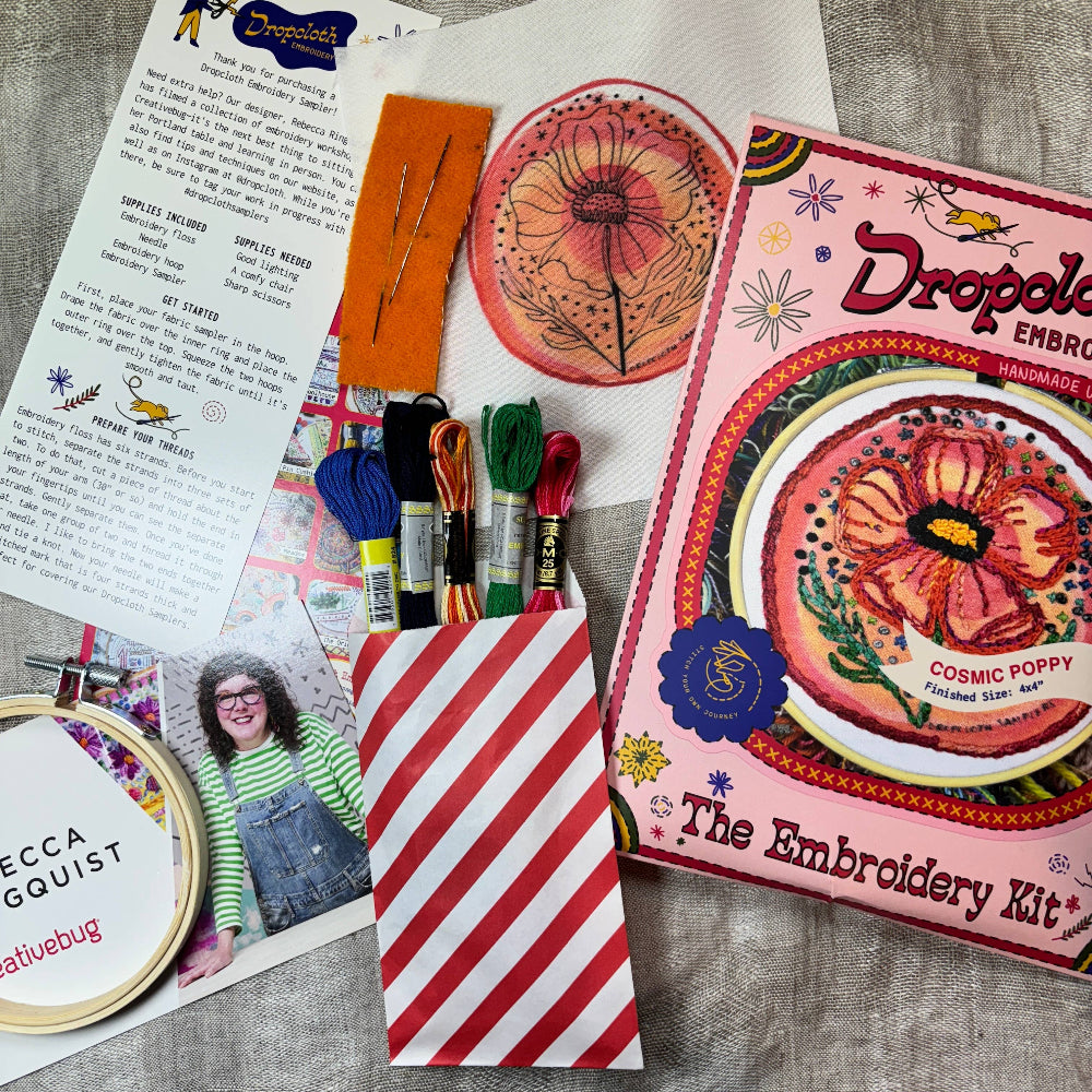 Embroidery kit with materials and instructions on a textured surface