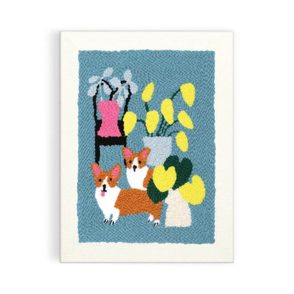 Punch needle art piece with two corgis and flowers on a blue background