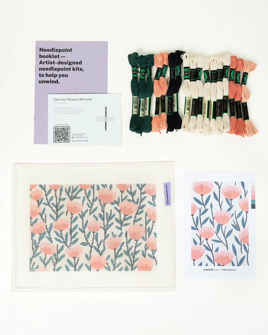 Needlepoint kit materials including a canvas, thread, and pattern on a white background
