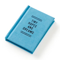 Blue notebook with 'Tiny Hopes and Dreams' text on a white background