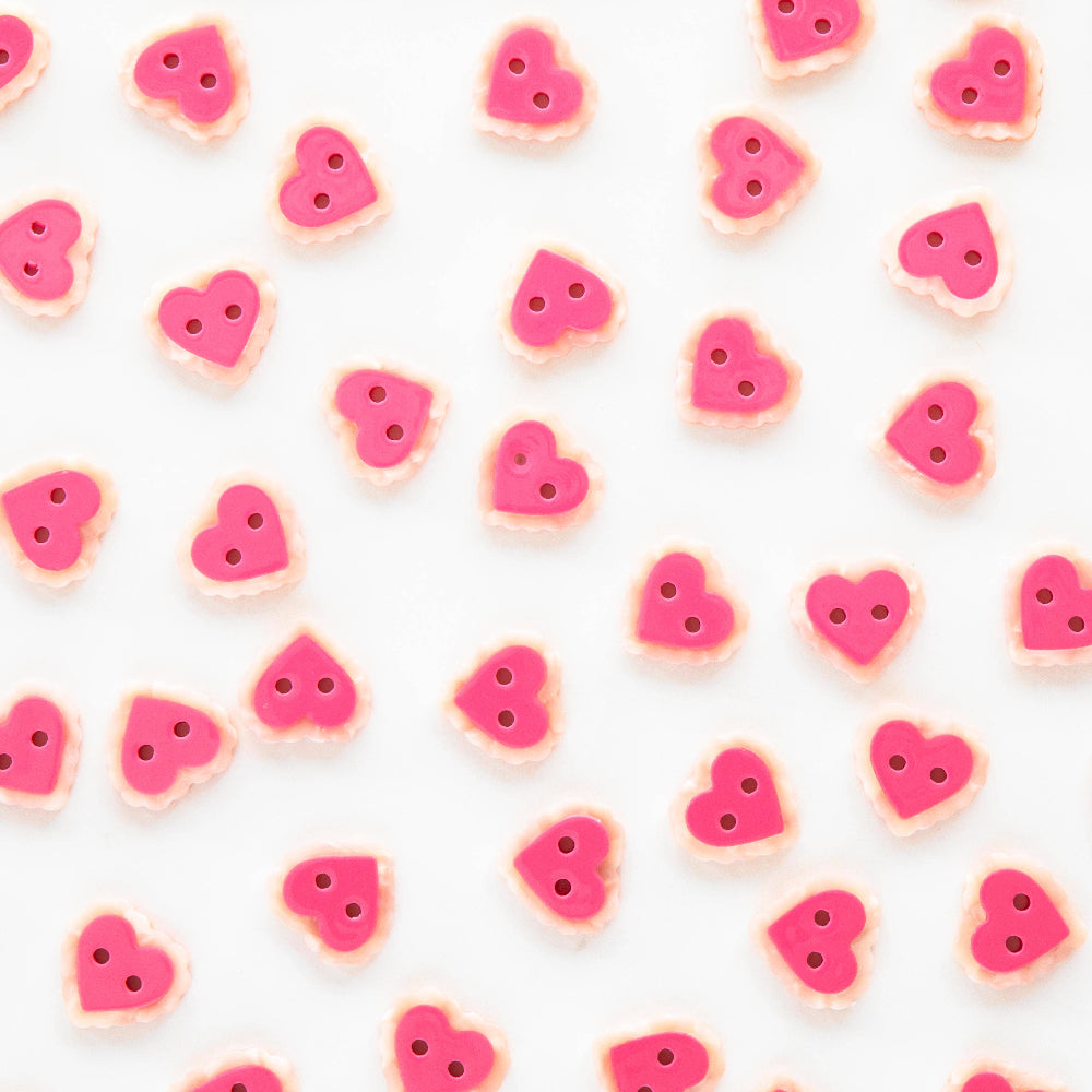 Pattern of pink heart-shaped buttons on a white background