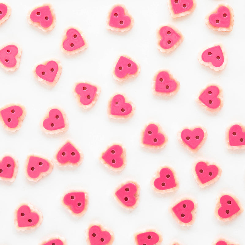 Pattern of pink heart-shaped buttons on a white background