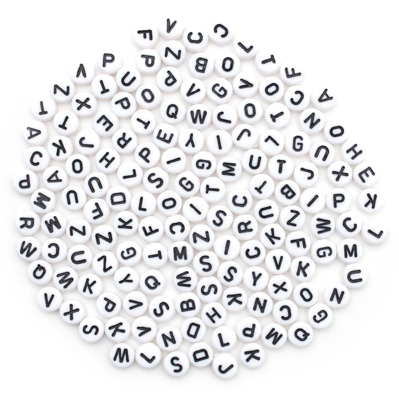 White beads with black letters scattered on a white background