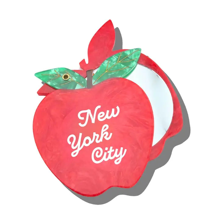 Compact mirror in the shape of a red apple with white text reading "New York City"