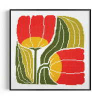 Framed cross-stitched artwork of red and yellow flowers with green leaves on a white background