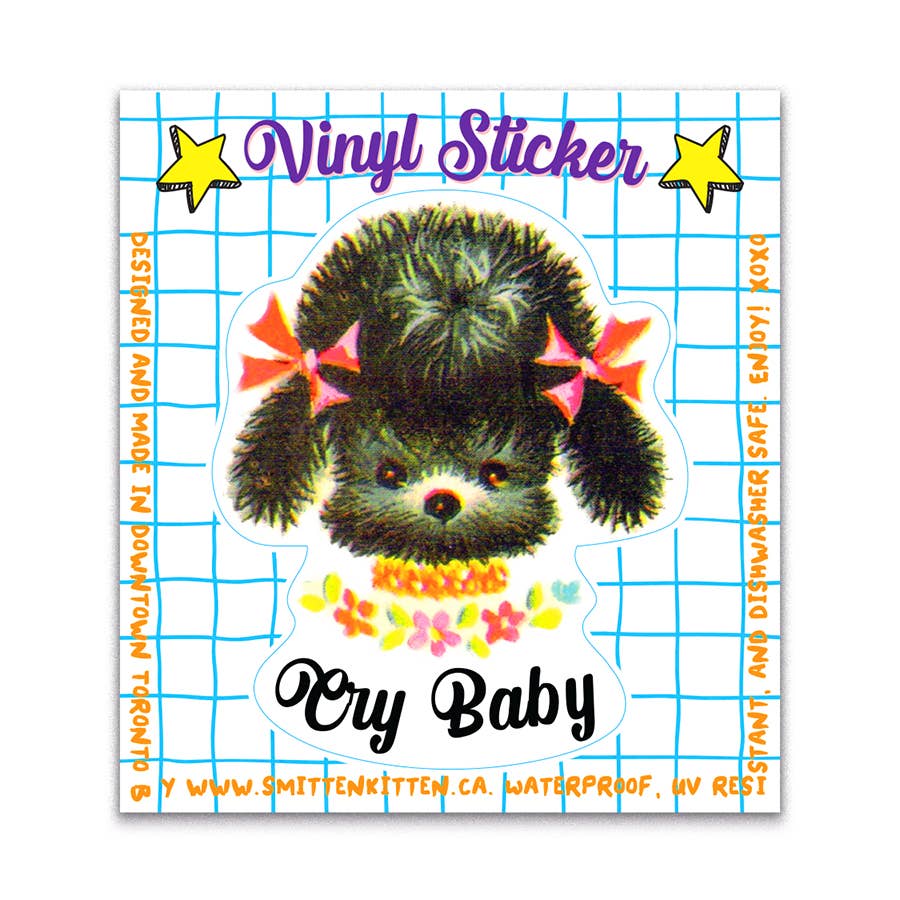Vinyl sticker with a cute illustration of a black kitten with bows and 'Cry Baby' text on a blue grid background.