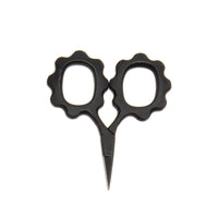 Black scissors with decorative handles on a white background