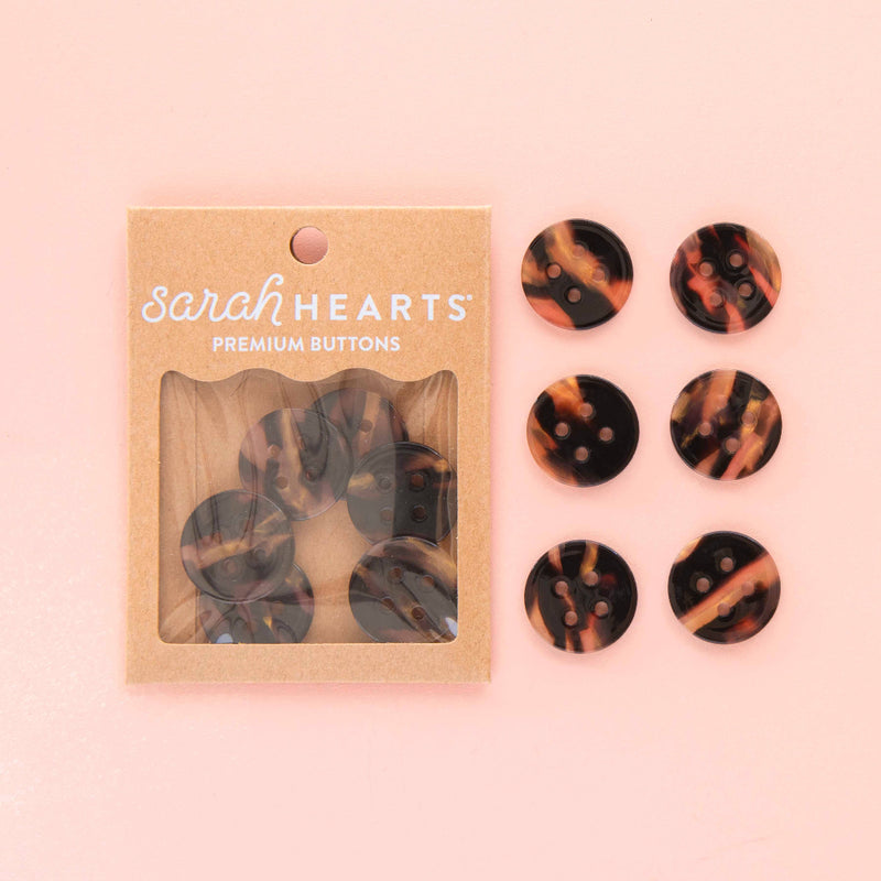 Packaged set of tortoiseshell patterned buttons with 'Sarah Hearts' branding on a pink background.