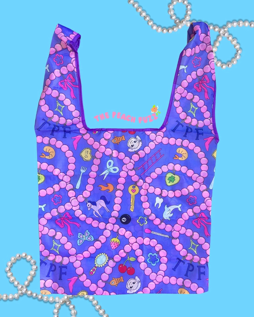 Reusable  purple bag bag with colorful patterns and text saying "
The Peach Fuzz" on a blue background