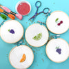 Embroidery hoops with fruit patterns on a blue background