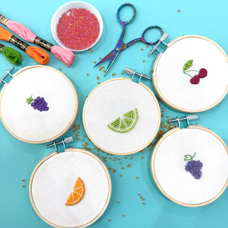 Embroidery hoops with fruit patterns on a blue background
