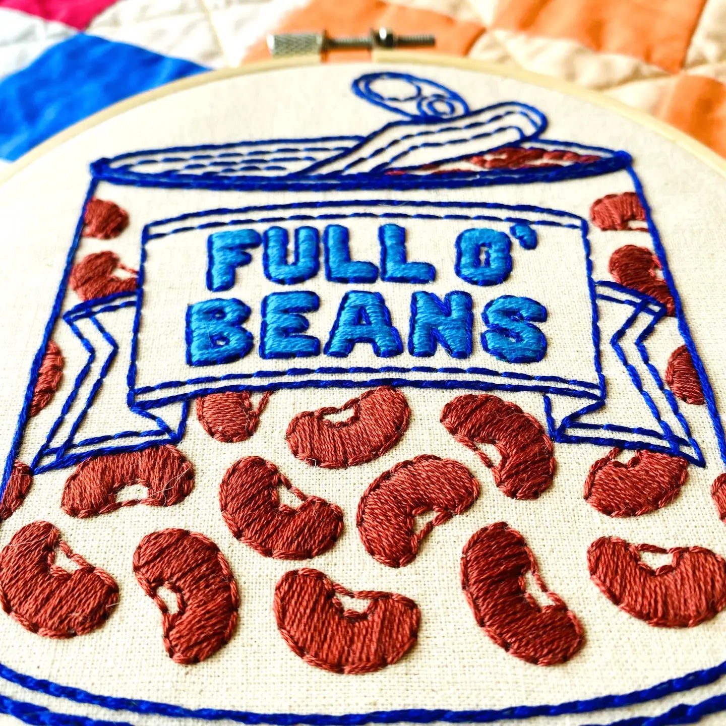 Embroidery hoop with 'Full O' Beans' design featuring red beans and blue text.