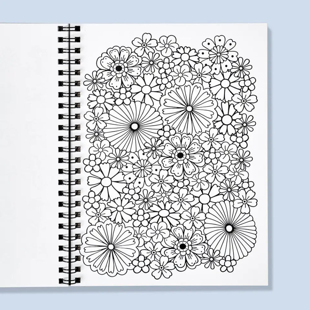Coloring book with black floral patterns on a white cover against a light blue background
