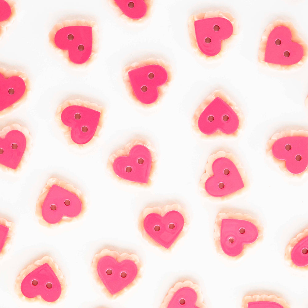 Pattern of pink heart-shaped buttons on a white background