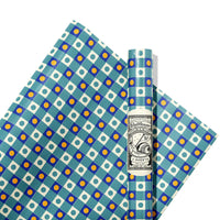Two rolls of patterned paper with blue, white, and yellow design, featuring a brand label in the center.