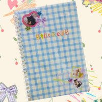 Notebook with blue and white checkered pattern and 'Stickers' text on a colorful background