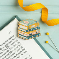 Stack of books needle minder with yellow ribbon on an open book