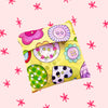Colorful bag with buttons folded up on a pink background with red stars