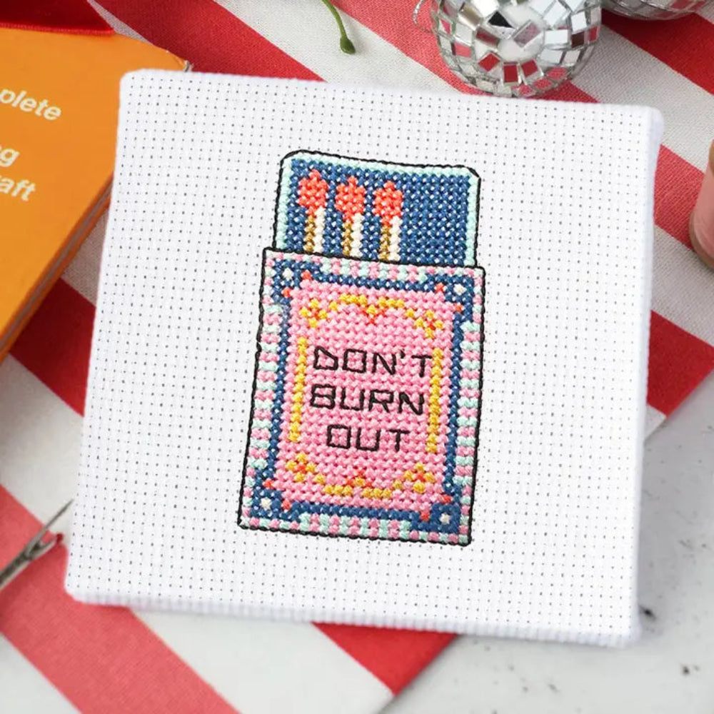 Cross-stitched Matchbox design on fabric with 'Don't Burn Out' text.