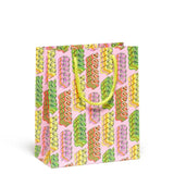 gift bag with ribbon candy on a a pink background 