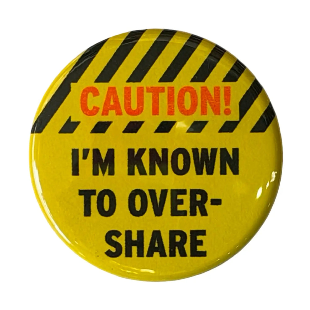 A yellow pin with a caution tape design on top and text that reads "Caution! I'm Known to Overshare". The word "Caution" is in red. 
