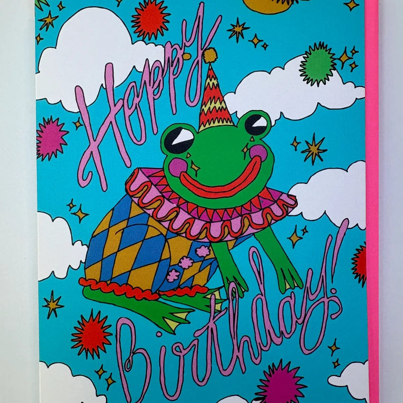 Colorful birthday card with a frog wearing a party hat and the text 'Happy Birthday!' on a blue background.