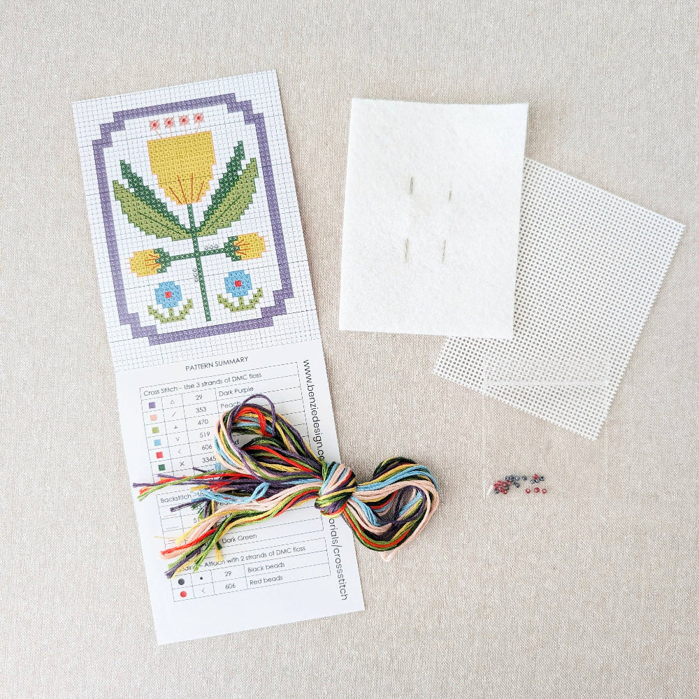 Kit includes beads, canvas, floss, needles, and color printed pattern on a white textured background