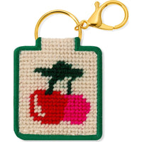 Keychain with a needlepointed cherries design on a beige background