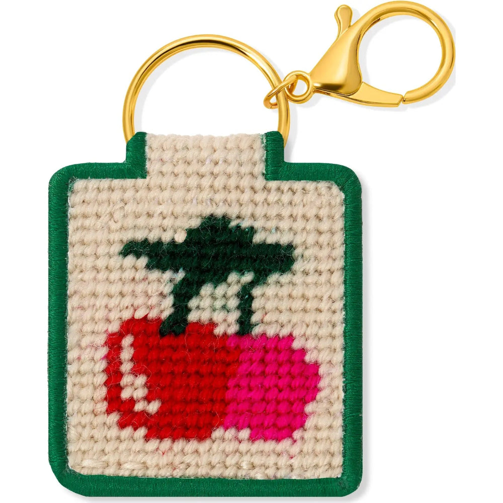 Keychain with a needlepointed cherries design on a beige background