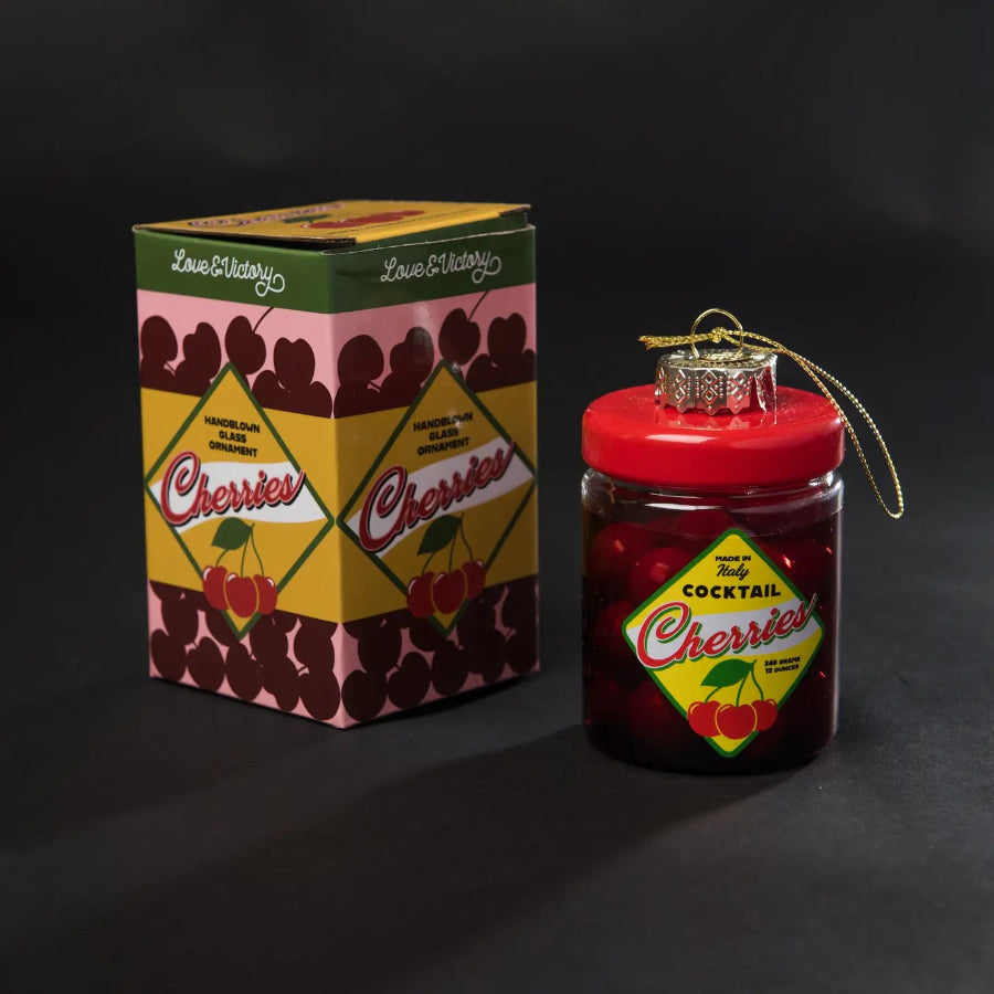 Jar of cocktail cherries with decorative box on a black background