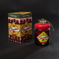 Jar of cocktail cherries with decorative box on a black background