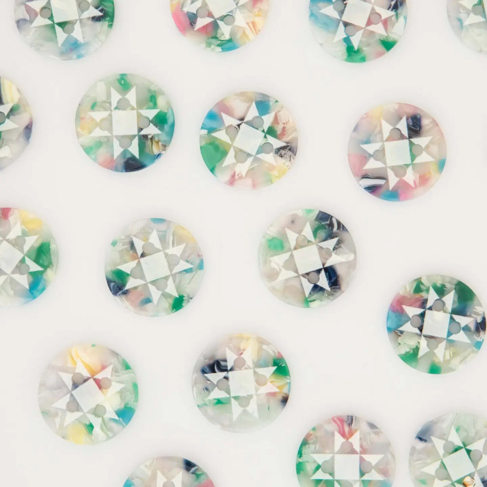 A close-up of multiple round faceted buttons arranged in a repeating pattern on a white background. Each button has a clear base with multicolored marbled inclusions in pastel and bright tones of green, blue, pink, yellow, and purple.