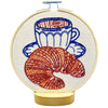 Embroidered croissant and cup of coffee on natural cloth with a white background
