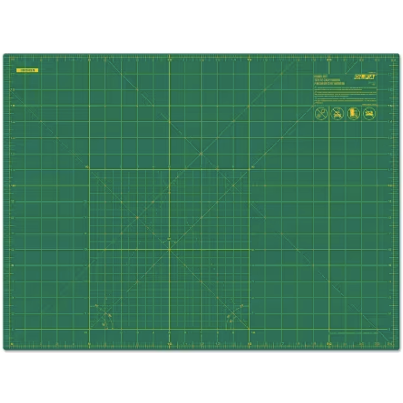 A green self-healing cutting mat with yellow grid lines and measurement markings, shown flat against a white background.