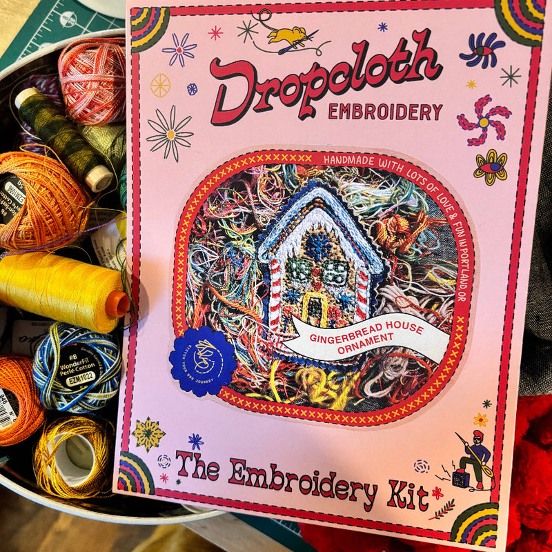 Embroidery kit packaging with colorful threads on a wooden surface