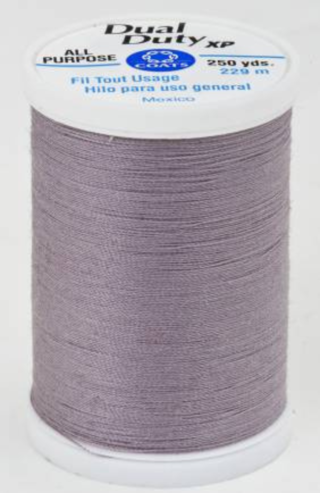 A spool of gray purple Dual Duty XP sewing thread with a white label featuring blue and black text, set against a plain white background.