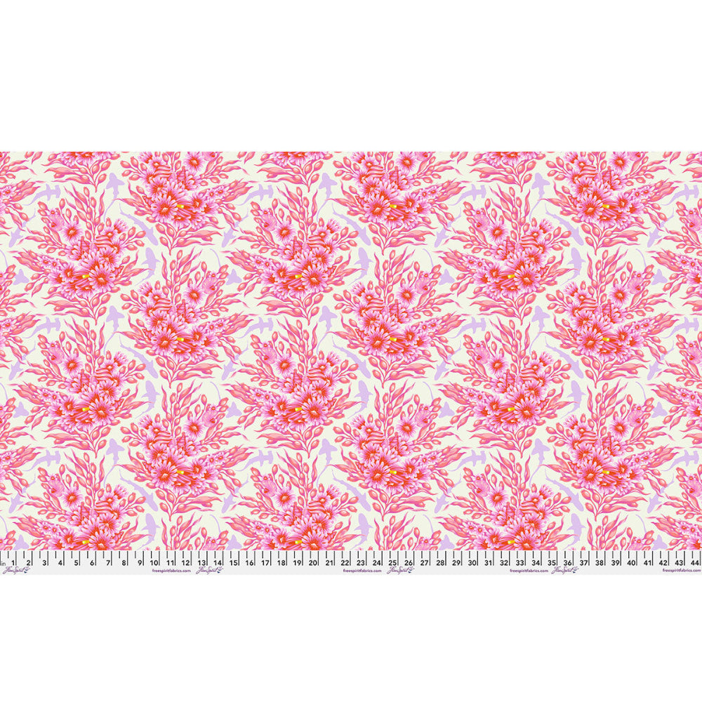 Patterned fabric with pink floral design with sharks in between on a white background with a ruler at the bottom.