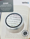Dome aluminum LED lighted rechargeable magnifier on an open book with 'WITHit' branding.