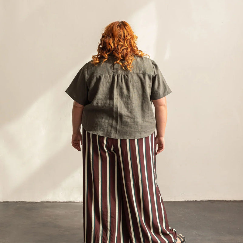 A woman with her back turned wearing a grey shirt.