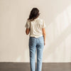 A woman with her back turned wearing a white shirt.