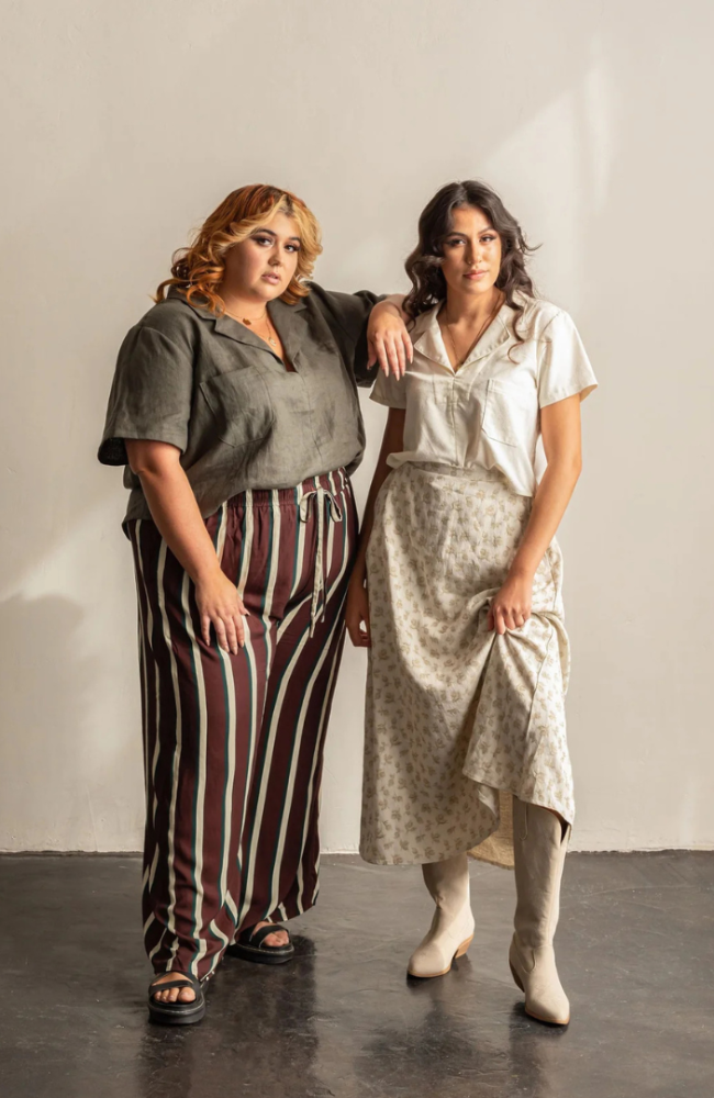 Two models leaning on each other wearing the Donny shirt in both gray and white on a gray and white background.