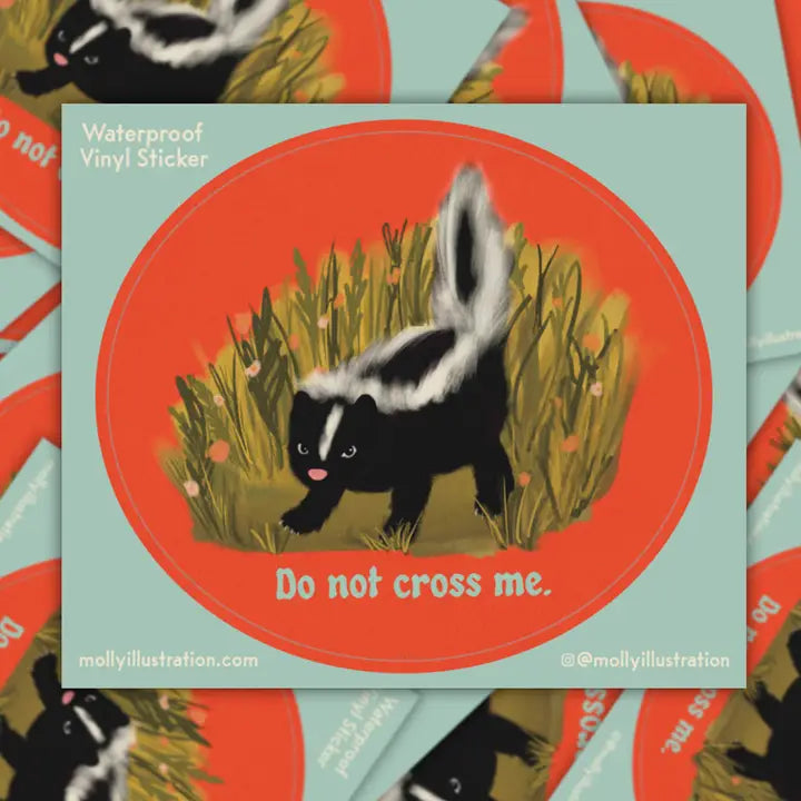 Sticker with a skunk illustration and text 'Do not cross me' on a red and green background.