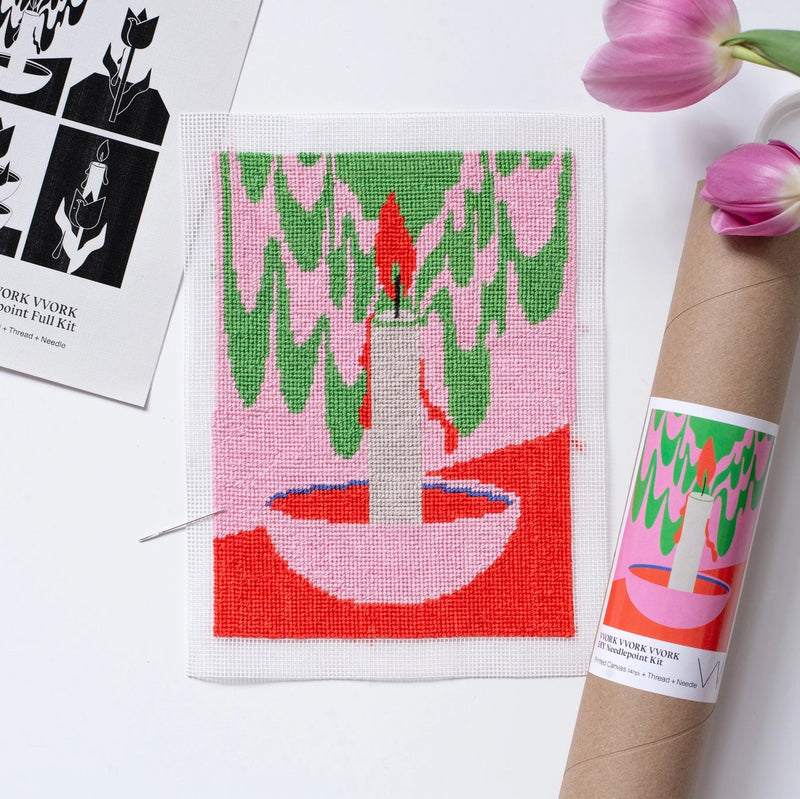Needlepoint canvas with hite candle in a pink bowl on a pink, red, and green background