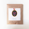 Cross stitch kit packaging with 'Raise Hell' design on a white background