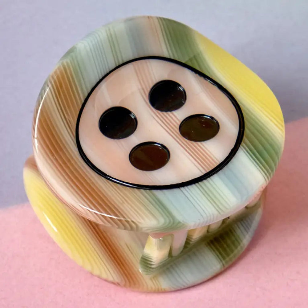 claw clip shaped like a button in orange, green, blue, and yellow stripes