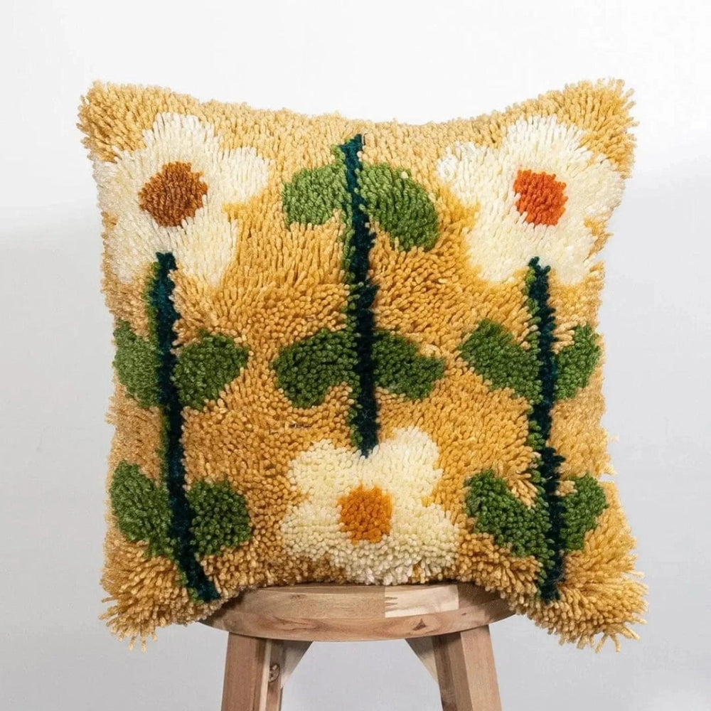 A fluffy pillow cushion featuring a mix of white petal flowers with green stems and leaves on a yellow background.
